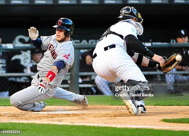 Roberto Perez of the Cleveland Indians scores as Tyler Flowers of the Chicago White Sox makes a late tag during the third inning on May 18, 2015 at...
