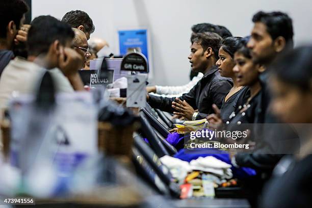 Employees serve customers at check-out counter in a Shoppers Stop Ltd. Store in the Malad area of Mumbai, India, on Sunday, May 17, 2015. Shoppers...