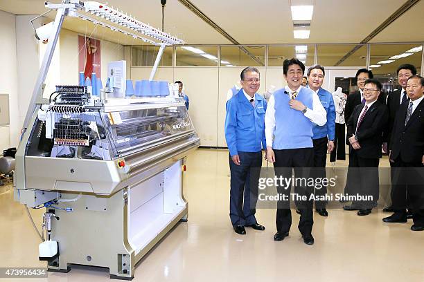 Japanese Prime Minister Shinzo Abe wears a vest knitted by the knitting machine at Shima Seiki MFG Ltd on May 17, 2015 in Wakayama, Japan. Abe is two...