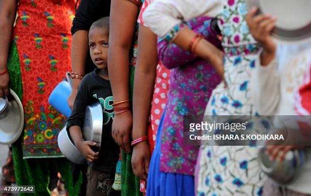 Nepalese people queue to receive food and goods at a relief camp for survivors of the Nepal earthquake in Kathmandu on May 19, 2015. Nearly 8,500...