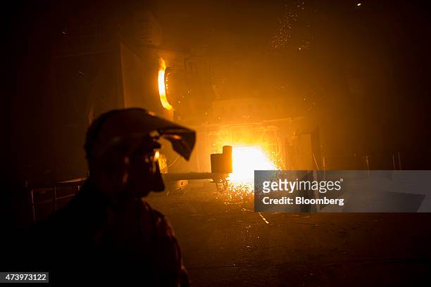 Worker watches as an electric arc furnace operates in the melt shop at the Celsa Steel UK Ltd. Steel mill in Cardiff, U.K., on Monday, May 18, 2015....
