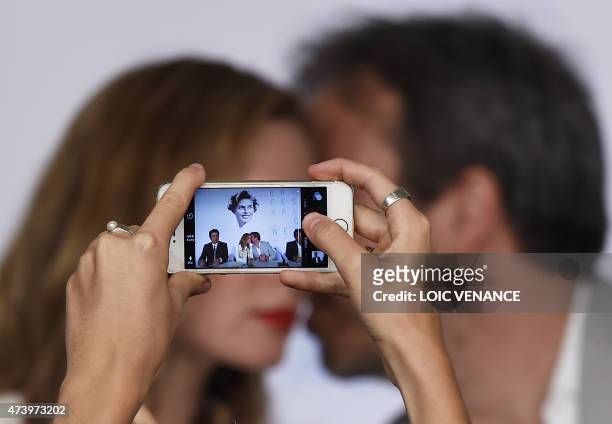 Journalist takes a photo of US-Puerto Rican actor Benicio Del Toro , British actress Emily Blunt and Canadian director Denis Villeneuve during a...
