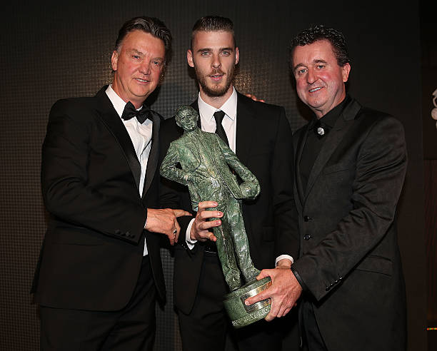 David de Gea of Manchester United is presented with the Sir Matt Busby Player of the Year trophy by Manager Louis van Gaal and auction winner Steve...
