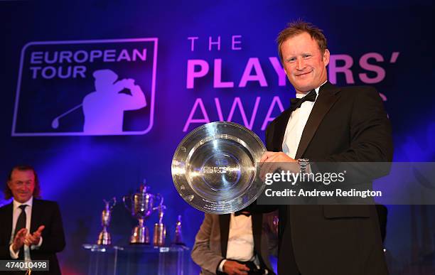 Jamie Donaldson of Wales receives the Shot of the Year award from Paul McGinley of Ireland during the European Tour Players' Awards ahead of the BMW...