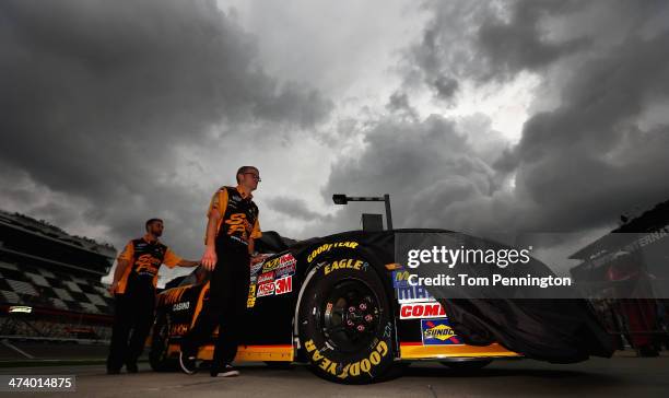 Crew members push the South Point Chevrolet of Brendan Gaughan into the garage area after qualifying for the NASCAR Nationwide Series DRIVE4COPD 300...