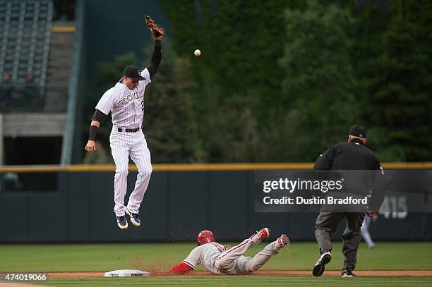 Ben Revere of the Philadelphia Phillies slides safely into second base with a steal as Troy Tulowitzki of the Colorado Rockies leaps but is unable to...