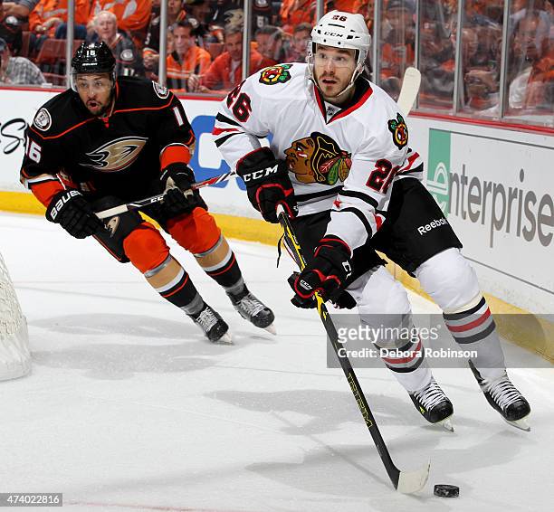 Kyle Cumiskey of the Chicago Blackhawks handles the puck against Emerson Etem of the Anaheim Ducks in Game Two of the Western Conference Finals...