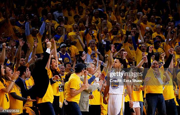 Fans react after Stephen Curry of the Golden State Warriors scored at the end of the seocnd quarter against the Houston Rockets during Game One of...