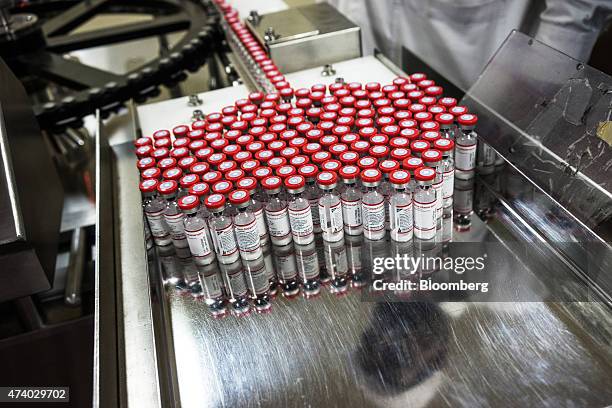 Vaccine vials exit a vaccine vial monitor labeling machine at the Serum Institute of India Ltd. Pharmaceutical plant in Pune, Maharashtra, India, on...