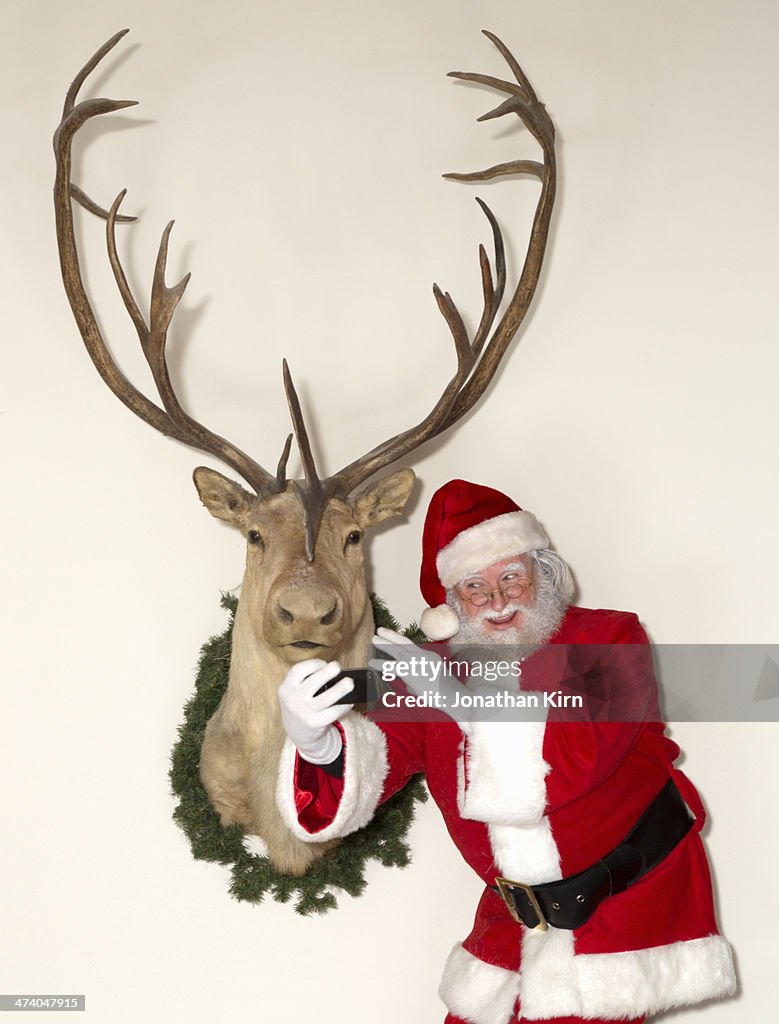 Santa shoots a selfie with a reindeer