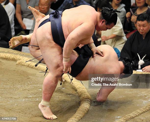 Ozeki Kisenosato throws his fellow ozeki Goeido to win during day ten of the Grand Sumo Summer Tournament at Ryogoku Kokugikan on May 19, 2015 in...