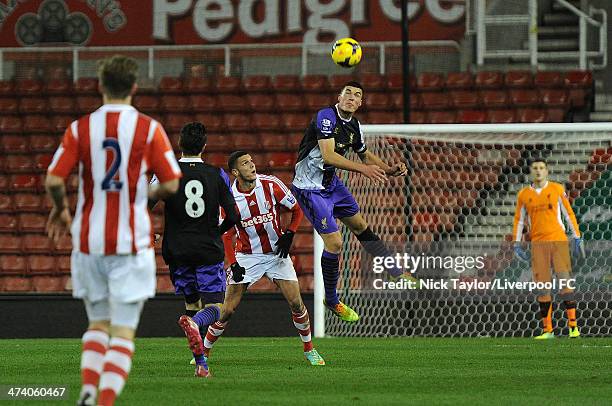 Lloyd Jones of Liverpool heads the ball clear as Stoke City's Karim Rossi looks on during the Barclays Premier League Under 21 fixture between Stoke...