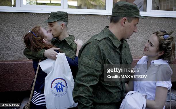 Russian army new conscript shares a tender moment with his girlfriend as he waits for the dispatch at the military registration and enlistment office...