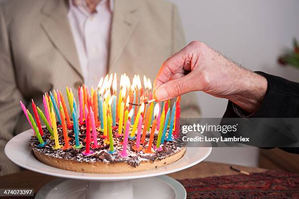 lighting 93 candles on a cake - 80 ans anniversaire photos et images de collection