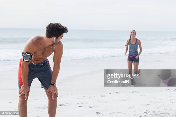 young couple running on the beach - gap closers stock pictures, royalty-free photos & images