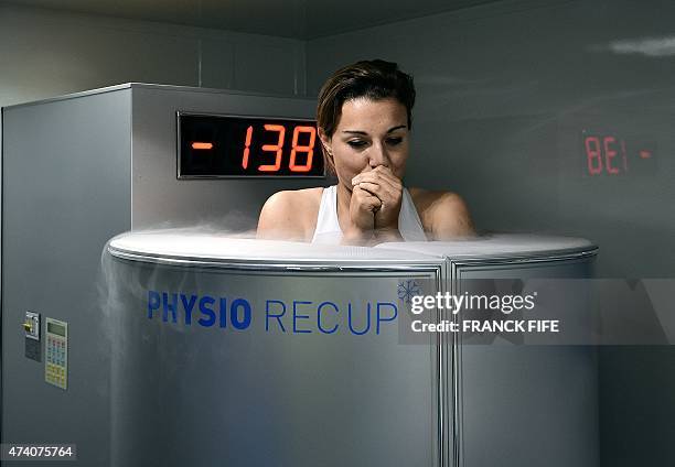 France's midfielder Claire Lavogez stands in a medical device used for cryotherapy at at the French national football team training base in...