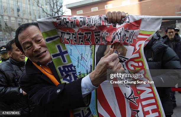 South Korean protester rips up a placard during an anti-Japan rally in front of the Japanese embassy on February 22, 2014 in Seoul, South Korea. Both...