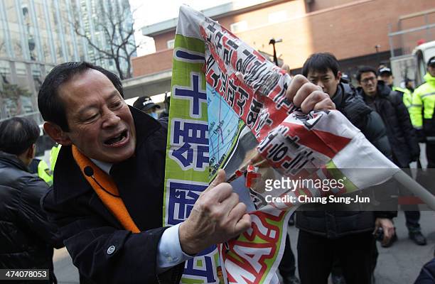 South Korean protester rips up a placard during an anti-Japan rally in front of the Japanese embassy on February 22, 2014 in Seoul, South Korea. Both...