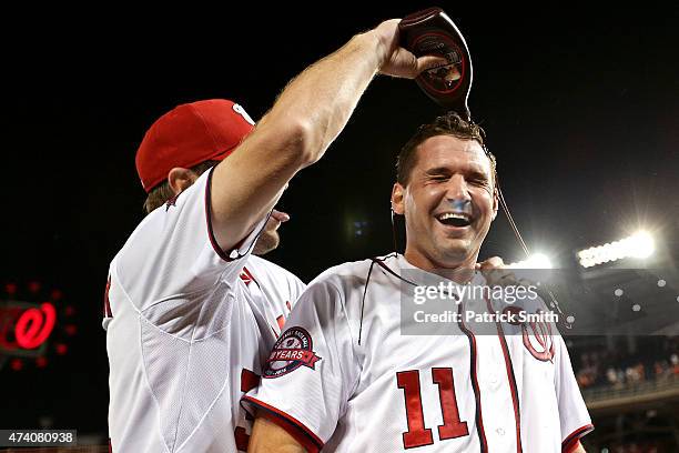 Ryan Zimmerman of the Washington Nationals has chocolate sauce dumped on him by teammate Max Scherzer after hitting a two run walk-off home run in...