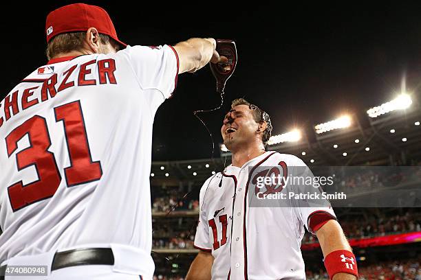 Ryan Zimmerman of the Washington Nationals has chocolate sauce dumped on him by teammate Max Scherzer after hitting a two run walk-off home run in...