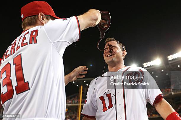 Ryan Zimmerman of the Washington Nationals has chocolate sauce dumped on him by teammate Max Scherzer after hitting a two run walk-off home run in...