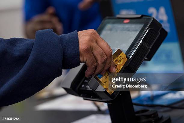 Customer slides a pre-paid American Express credit card through a card reader at a Best Buy Co. Store in San Francisco, California, U.S., on Friday,...