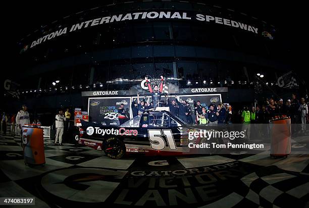 Kyle Busch, driver of the ToyotaCare Toyota, celebrates in Victory Lane with the trophy after winning during the Camping World Truck Series NextEra...