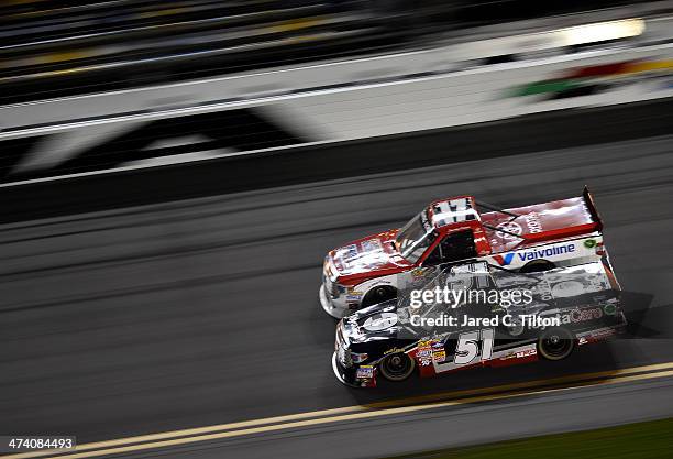 Kyle Busch, driver of the ToyotaCare Toyota, and Timothy Peters, driver of the Valvoline Toyota, race during the Camping World Truck Series NextEra...