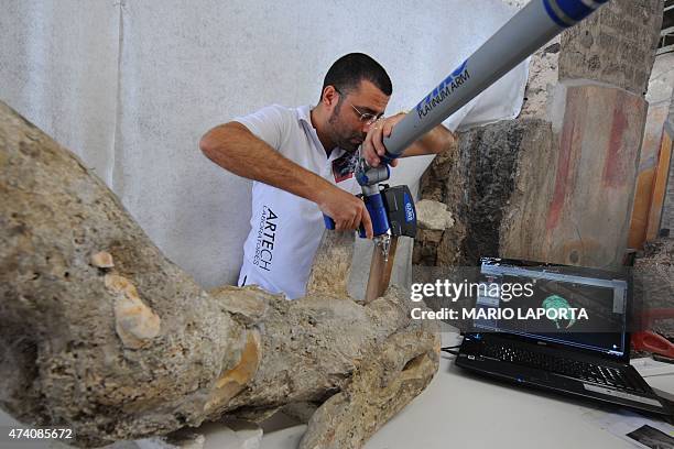 Restorer works with a laser scaner on a petrified victim of the eruption of Vesuvius volcano in 79 BC, as part of the restoration work and the study...