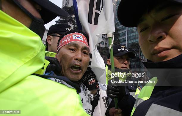 South Korean policemen detain a protester during an anti-Japan rally in front of the Japanese embassy on February 22, 2014 in Seoul, South Korea....