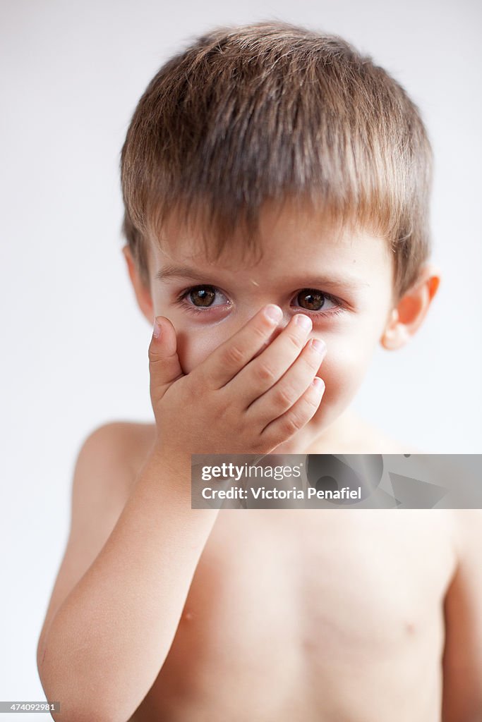 Portrait of toddler with hand on mouth