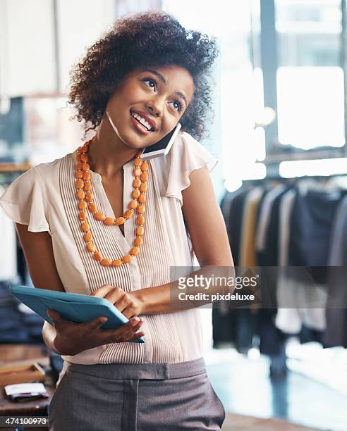 running your own boutique is no easy task - african american woman with tablet stockfoto's en -beelden