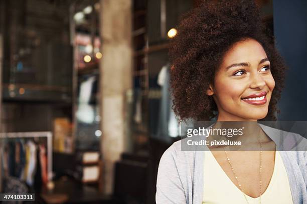 sonriente mujer étnica de pie fuera de casa de café - mirada de reojo fotografías e imágenes de stock