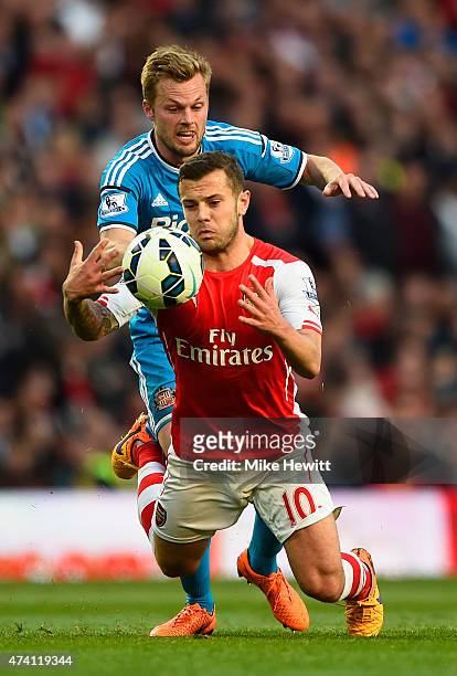 Jack Wilshere of Arsenal and Sebastian Larsson of Sunderland compete for the ball during the Barclays Premier League match between Arsenal and...