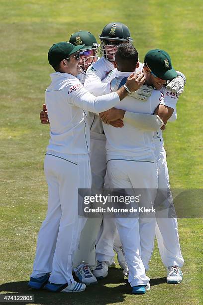 South African players congratulate JP Duminy after he bowled out Mitchell Johnson of Australia during day three of the Second Test match between...