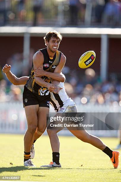 Ben Griffiths of Richmond handballs during the NAB challenge match between the Collingwood Magpies and the Richmond Tigers on February 22, 2014 in...