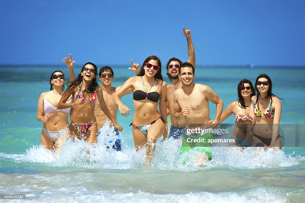 Groupe de jeunes de vous baigner dans les eaux turquoise de l'île tropicale de plage