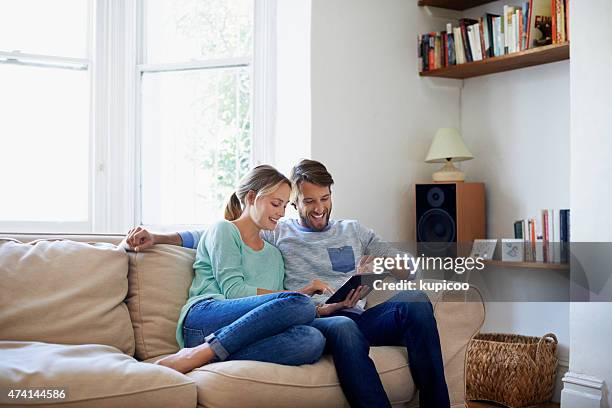 spending a day online - couple with ipad in home stock pictures, royalty-free photos & images