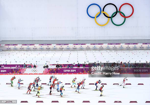 Athletes pass the Olympic Rings as they compete during the Men's 4 x 7.5 km Relay during day 15 of the Sochi 2014 Winter Olympics at Laura...