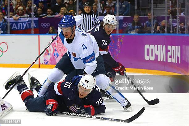 Ossi Vaananen of Finland stands over Paul Stastny of the United States in the first period during the Men's Ice Hockey Bronze Medal Game on Day 15 of...