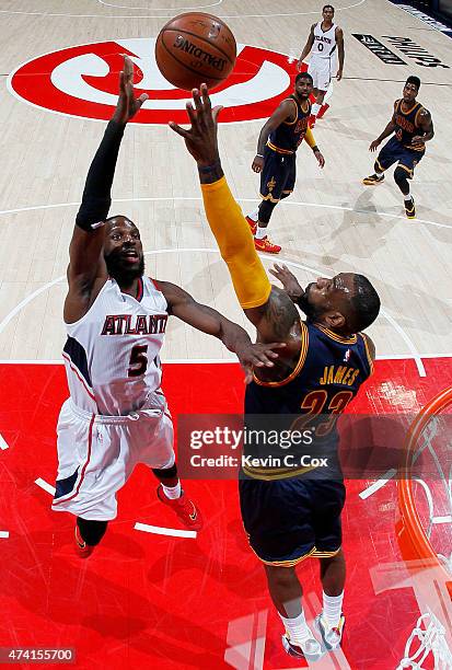 DeMarre Carroll of the Atlanta Hawks shoots against LeBron James of the Cleveland Cavaliers in the first half during Game One of the Eastern...