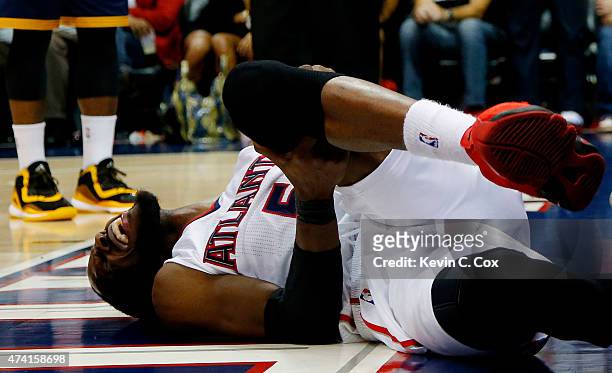 DeMarre Carroll of the Atlanta Hawks reacts after injuring his left leg in the fourth quarter against the Cleveland Cavaliers during Game One of the...