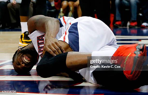 DeMarre Carroll of the Atlanta Hawks reacts after injuring his left leg in the fourth quarter against the Cleveland Cavaliers during Game One of the...