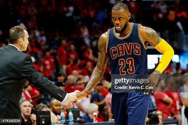 LeBron James of the Cleveland Cavaliers celebrates their 97 to 89 win over the Atlanta Hawks with head coach David Blatt during Game One of the...