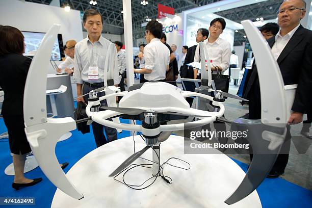 Attendees look at the Amuse Oneself Inc. ZUAV multi-rotor unmanned aerial vehicle at the International Drone Expo in Chiba, Japan, on Wednesday, May...