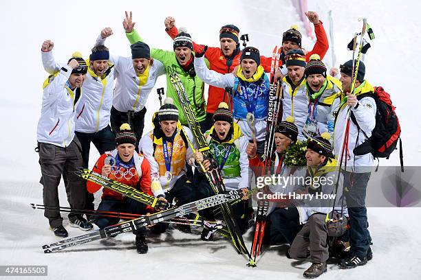 Silver medalists Erik Lesser, Arnd Peiffer, Daniel Boehm and Simon Schempp of Germany celebrate with members of their team after the medal ceremony...