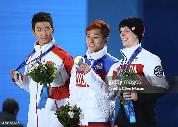 Silver medalist Dajing Wu of China, gold medalist Victor An of Russia and bronze medalist Charle Cournoyer of Canada celebrate on the podium during...