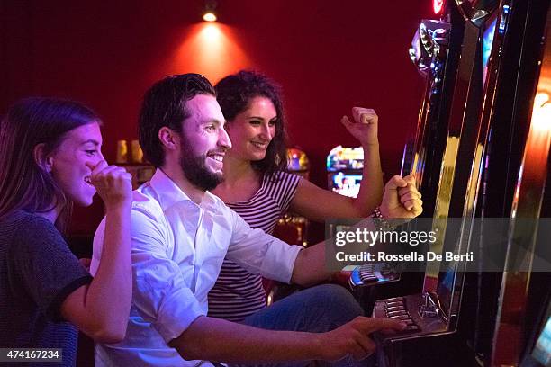 friends playing the slots - coin operated stockfoto's en -beelden