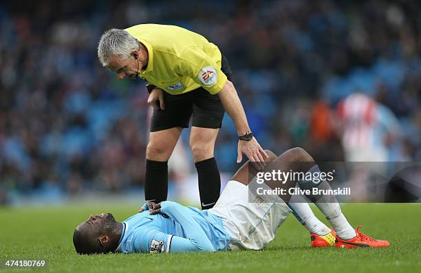 Referee Chris Foy checks to see if Yaya Toure of Manchester City is ok as he lies injured after a bad tackle during the Barclays Premier League match...