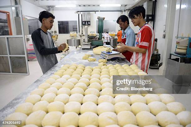 Employees shape balls of dough with their hands at the Tan Ek Tjoan bread factory in Ciputat, Banten Province, Indonesia, on Wednesday, May 20, 2015....